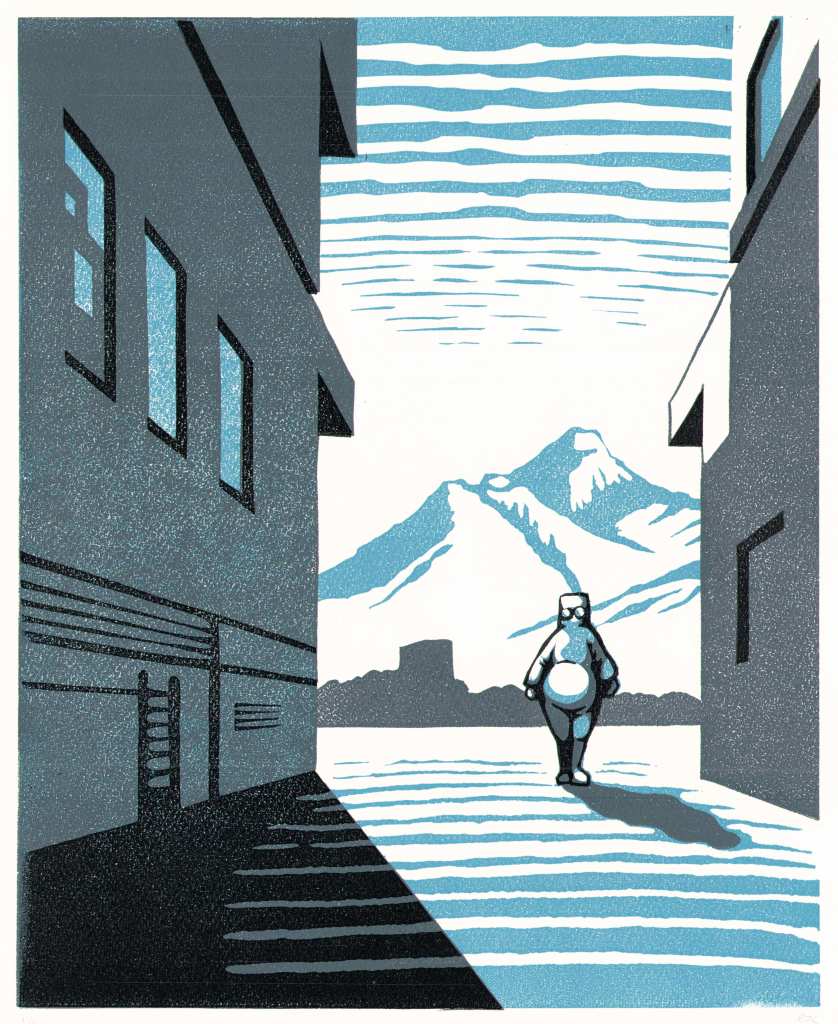 A figure walks between two concrete buildings against a background of mountains